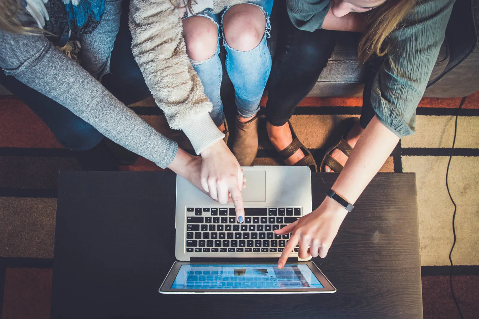 Personen zeigen auf ein e Learning im Laptop